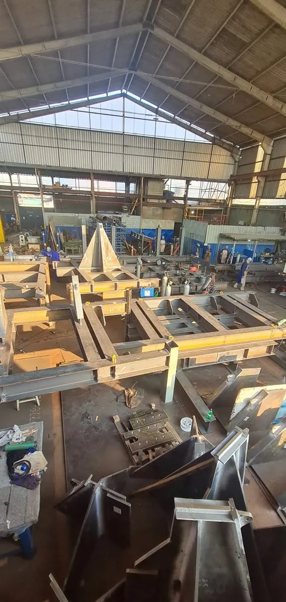 Vista do galpão de caldeiraria com estruturas de grande porte em montagem